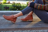 Woman wearing Falcon leather booties in cognac with jeans and sweater.