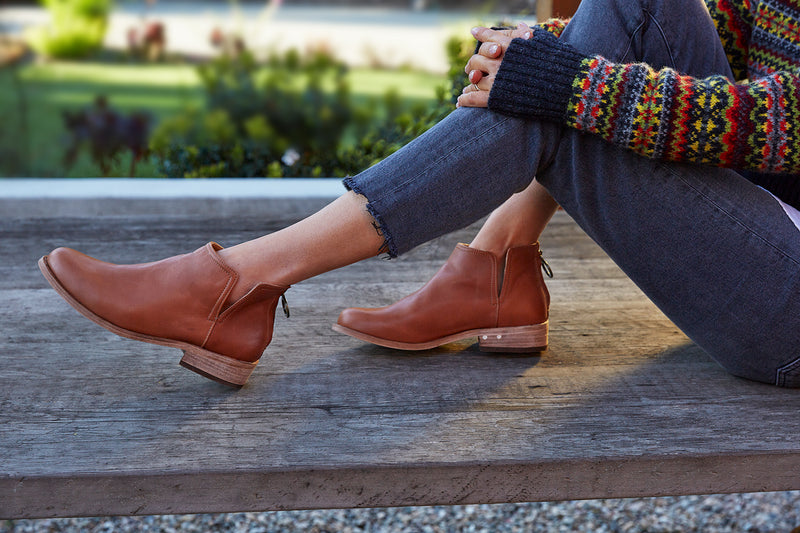 Woman wearing Falcon leather booties in cognac with jeans and sweater.