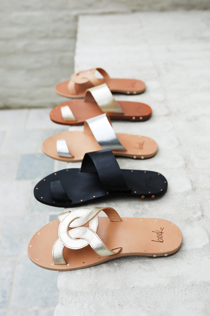 Batis leather slide sandals in platinum beach and honey with Finch leather toe-ring sandals in black, silver/beach, and platinum/honey.