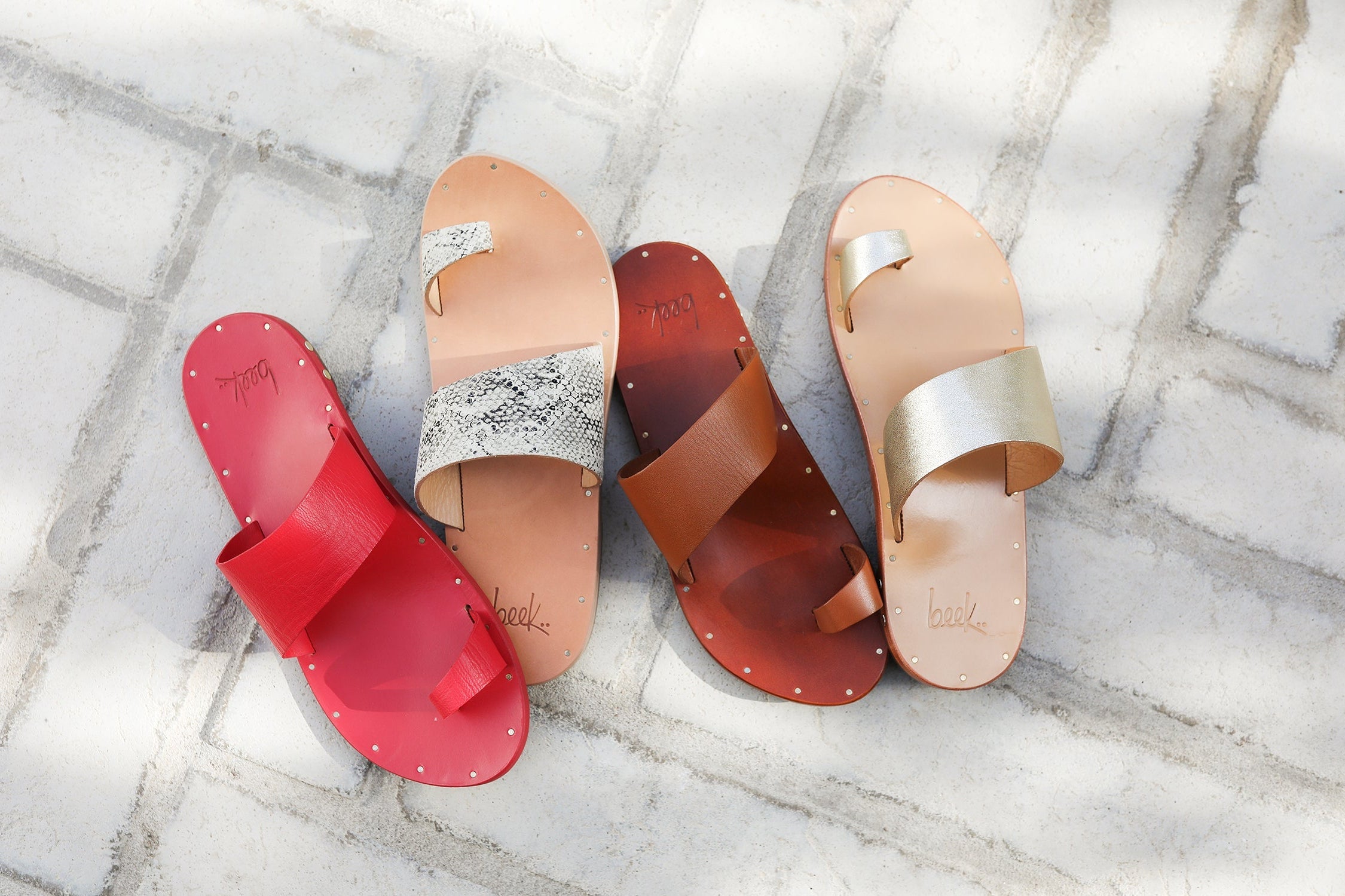 Group shot of Finch leather toe-ring sandals in tan, platinum/honey, and snake/beach