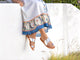 Woman wearing Finch leather toe-ring sandal in high shine silver with dress