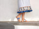 Woman wearing Finch leather toe-ring sandal in high shine silver with dress