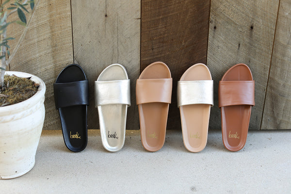 Gallito leather slides in black, platinum, honey, platinum/beach, and tan.