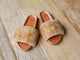 Gallito Más Shearling slide sandals in honey/tan on wooden floor