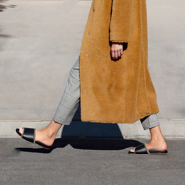 Woman wearing Gallito Shearling leather sandals in black._
