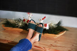 Woman wearing Gallito Shearling suede slides in forest with jeans by holiday decorations