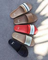 Group shot of Gallito Stripe leather slide sandals in tomato and beach with Gallito slide sandals in honey, platinum/beach, and black