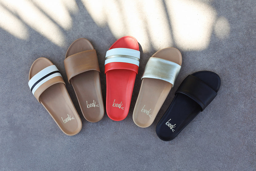 Group shot of Gallito Stripe leather slide sandals in tomato and beach with Gallito slide sandals in honey, platinum/beach, and black