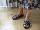 Woman wearing Gallito Stud leather slide sandal in black with floral dress