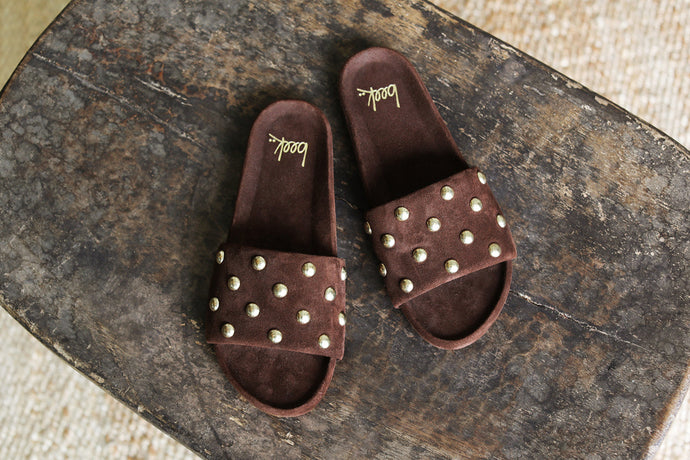Gallito Stud suede slide sandal in coffee on stone surface