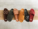 Group shot of Gallito Stud suede sandal in coffee, Kea suede slide sandal in ivy, Gallito Stud leather slide sandal in tan, Kea suede sandal in caramel, Gallito Stud leather slide sandal in black, and Gallito Stud suede slide sandal in port.