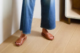 Woman wearing Gallito leather slide sandals in tan with jeans.