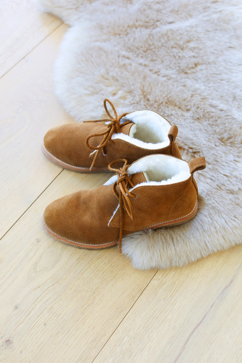 Goose suede shearling boot in chestnut on a rug