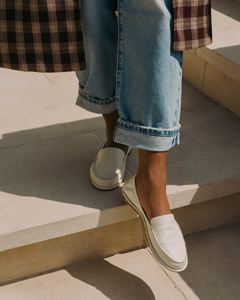 Woman wearing Griffin suede loafer in vanilla with jeans and coat