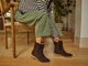 Woman wearing Grouse slouchy suede boot in coffee with olive pants and striped top