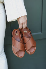 Woman holding Gull leather platform sandal in cognac