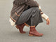 Woman wearing Hawk leather ankle boot in mahogany with gray pants and fringed sweater