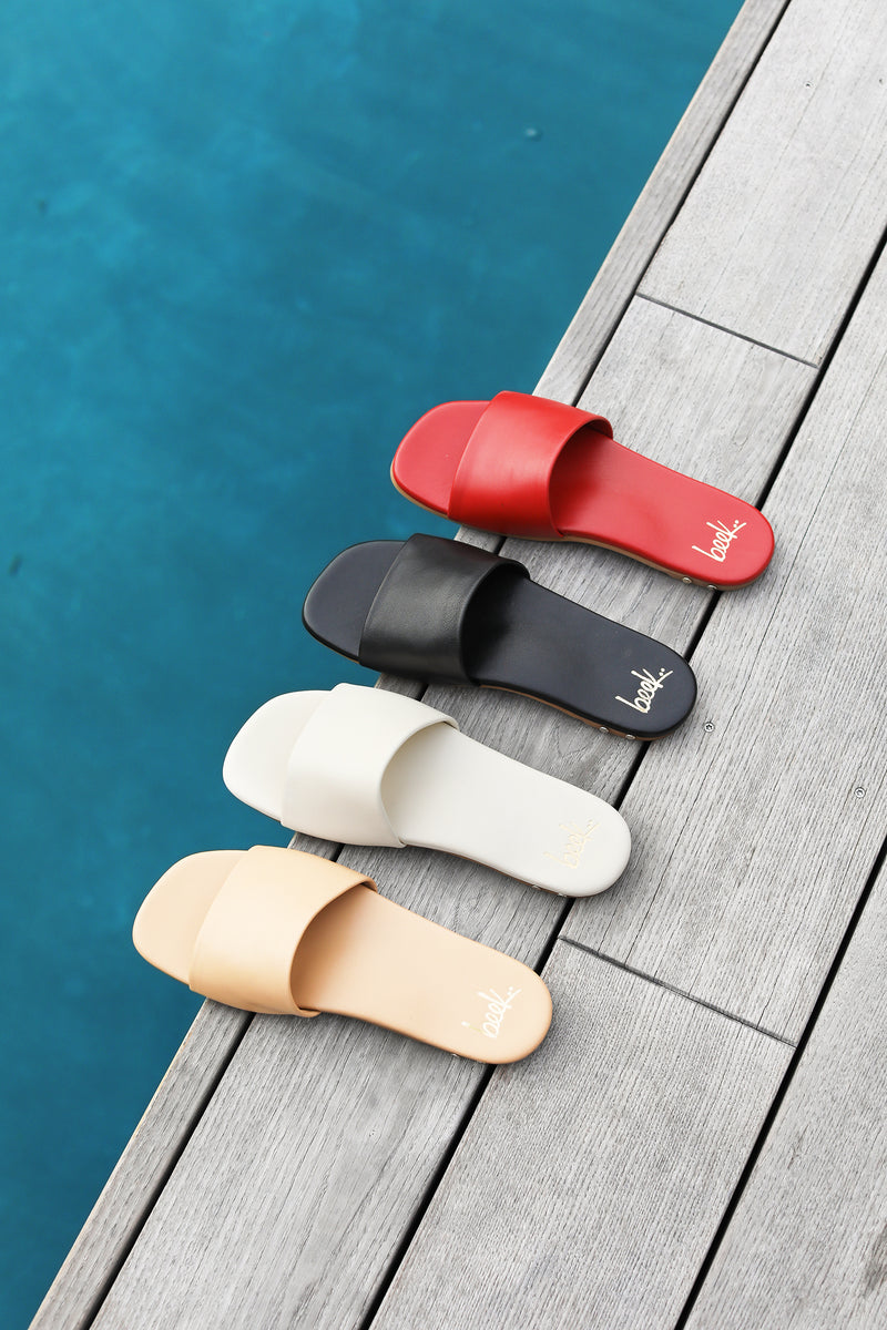 Honeybird leather slide sandals in beach, eggshell, black, and red