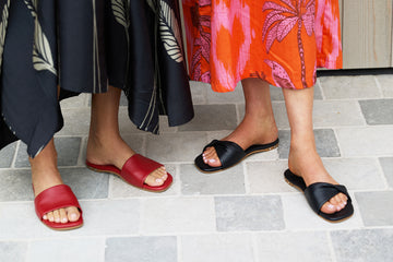 Women wearing Honeybird leather slide sandal in red and Whipbird leather slide sandal in black 