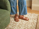 Woman wearing Huet leather buckle sandals in cognac with jeans