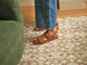 Woman wearing Huet leather buckle sandals in cognac with jeans