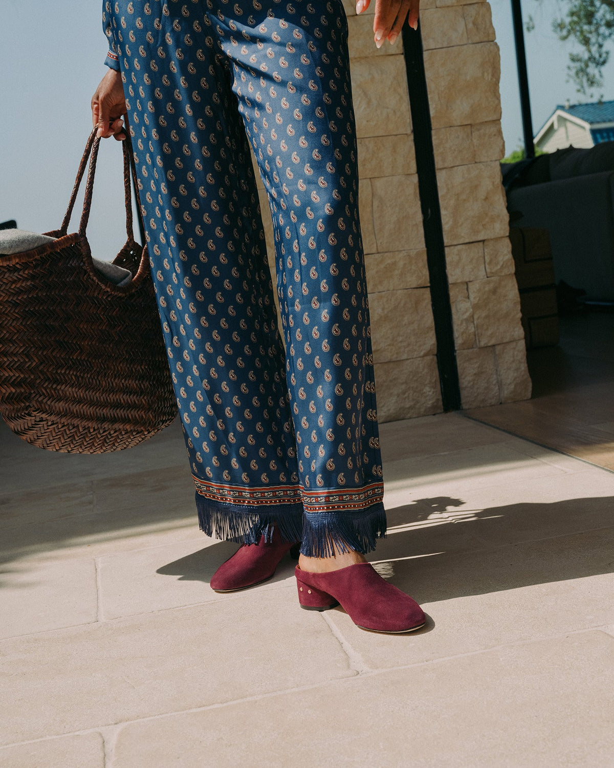 Woman wearing Jay suede heeled mules in prune with patterned pants