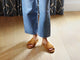 Woman wearing Kea suede slide sandals in caramel with jeans