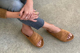 Woman wearing Kea suede slide sandals in caramel.