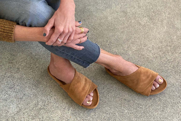 Woman wearing Kea suede slide sandals in caramel.