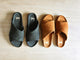 Group shot of Kea suede slide sandals in ivy and caramel on wood surface
