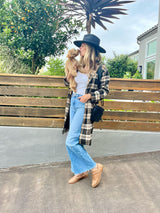 @kimhalfkept wearing Puffin leather booties in saddle, holding dog.