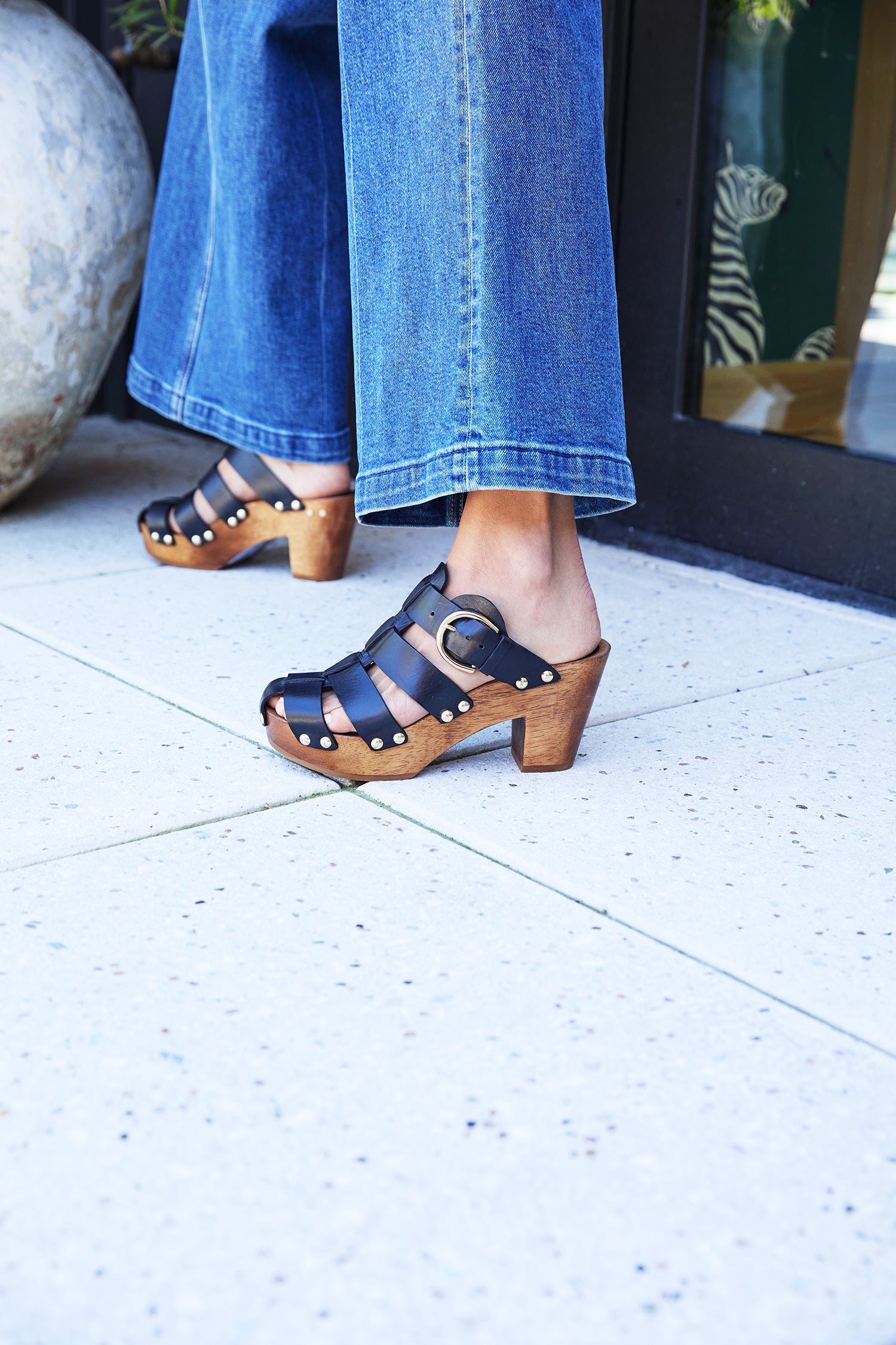 Woman wearing Magpie leather heeled clogs in black with jeans