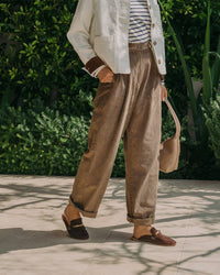 Woman wearing Mallard suede loafer mule in coffee with pants