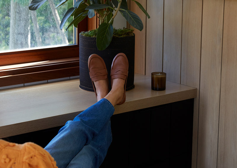 Woman wearing Moorhen leather moccasins in cognac.