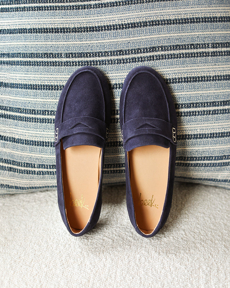 Moorhen suede loafers in navy propped on pillow