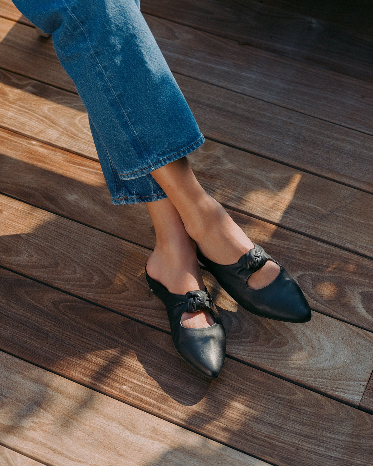 Woman wearing Noddy leather backless ballet mule in black with jeans