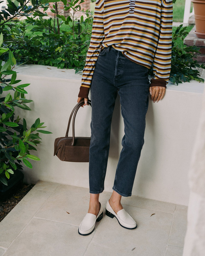 Woman wearing Owl leather heeled loafers in eggshell with jeans and striped top