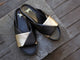 Paloma leather slide sandal in bronze/black on wooden stoop