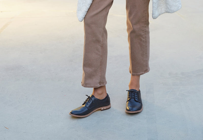 Woman wearing Partridge leather oxford shoes in black with brown pants.