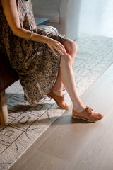 Woman wearing Partridge leather oxford shoes in cognac with floral dress.