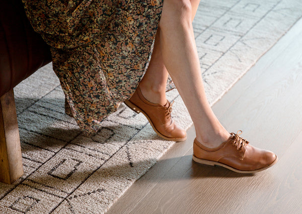 Woman wearing Partridge leather oxford shoes in cognac with floral dress.
