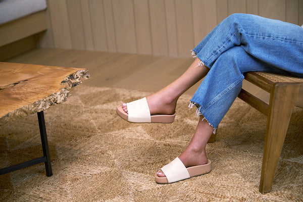 Woman wearing Pelican leather platform sandals in eggshell/beach with jeans.