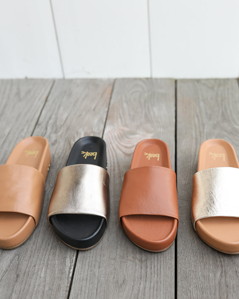 Group shot of Pelican leather slide sandals in honey, bronze/black, tan, platinum/beach