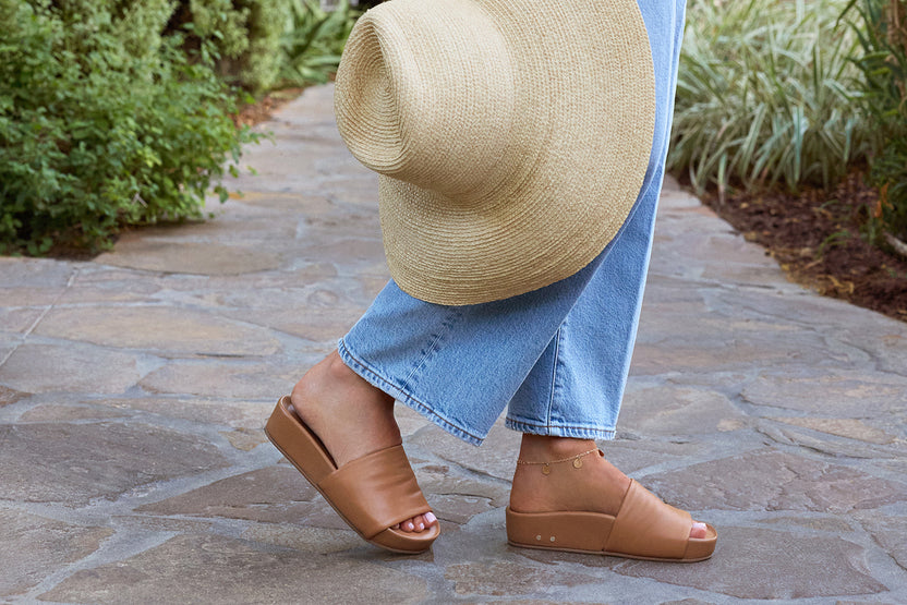 woman wearing Pelican leather platform slide sandals in honey with jeans