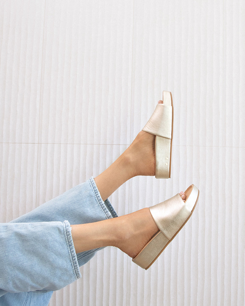 Woman wearing Pelican leather platform sandals in platinum with jeans