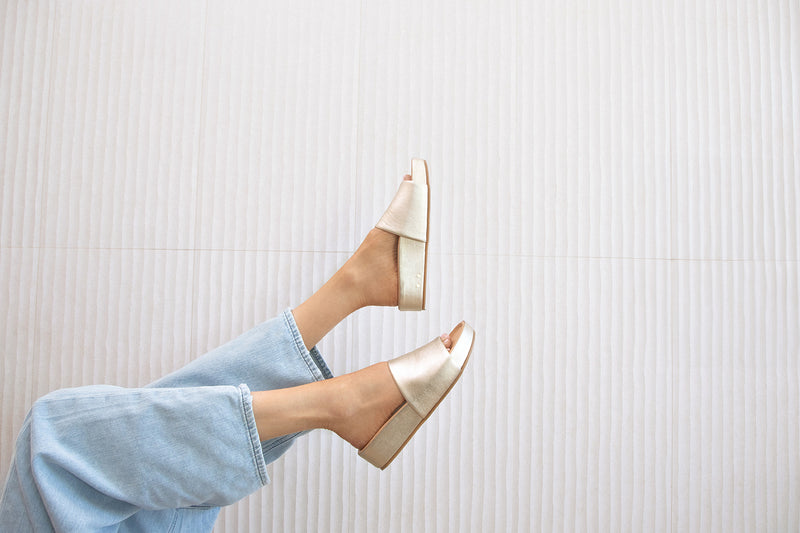 Woman wearing Pelican leather platform sandals in platinum with jeans