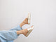 Woman wearing Pelican leather platform sandals in platinum with jeans