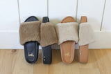 Group shot of Pelican Shearling platform slide sandals in black/bronze and natural/honey.