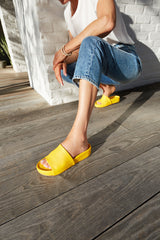 Woman wearing Pelican leather platform sandals in sunflower with jeans