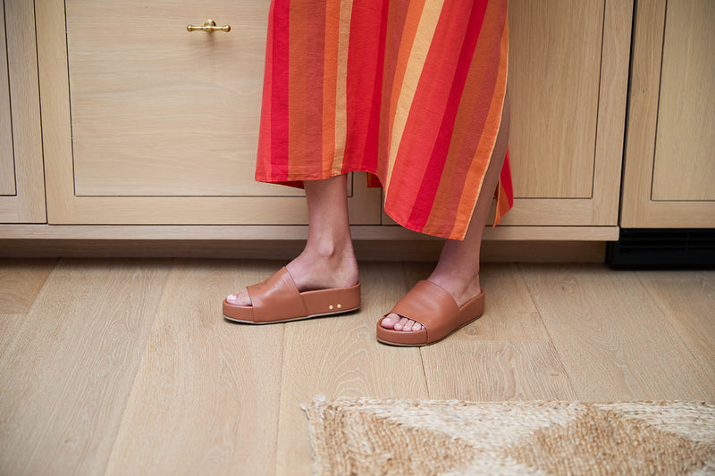 Woman wearing Pelican leather platform sandals in tan with striped dress